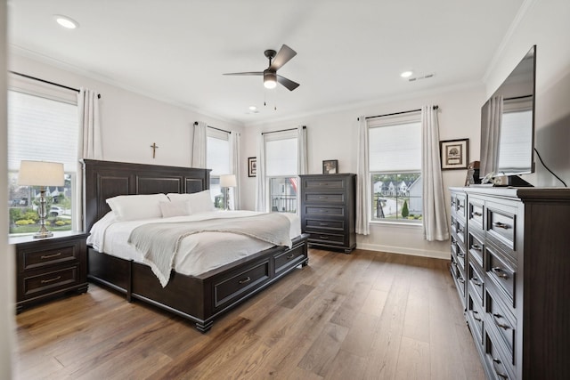 bedroom featuring baseboards, ceiling fan, ornamental molding, wood finished floors, and recessed lighting