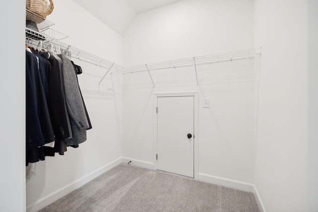 spacious closet with light carpet and vaulted ceiling