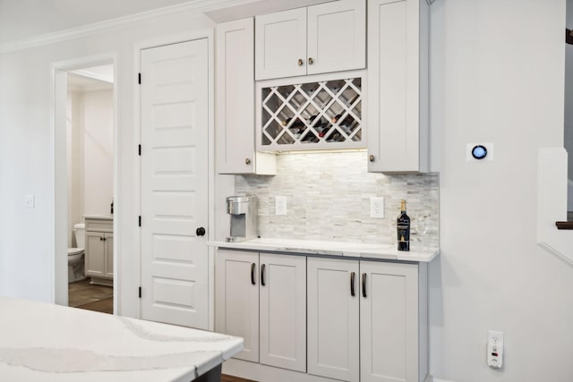 bar with a bar, backsplash, and crown molding