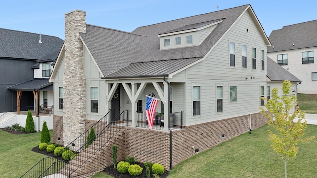 view of front of property with covered porch, a shingled roof, a front lawn, and a standing seam roof