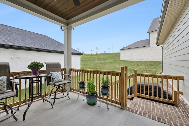 wooden deck featuring a lawn