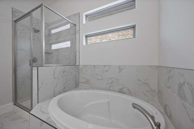 full bathroom with marble finish floor, a shower stall, and a bath