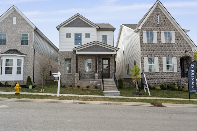 view of front facade featuring covered porch and brick siding