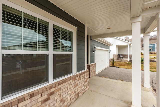 view of patio / terrace featuring aphalt driveway and a garage