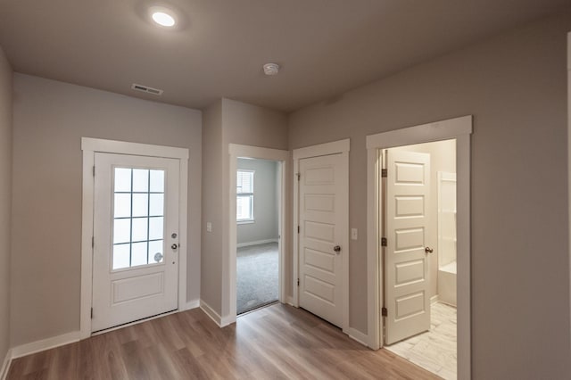 entryway with light wood-type flooring, visible vents, and baseboards