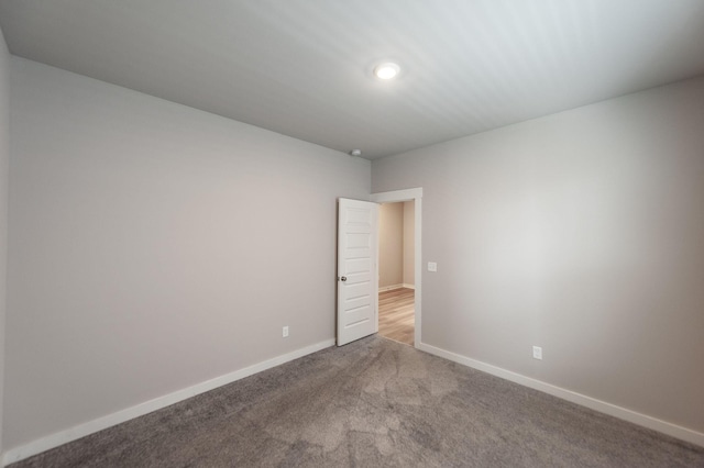 carpeted empty room featuring baseboards