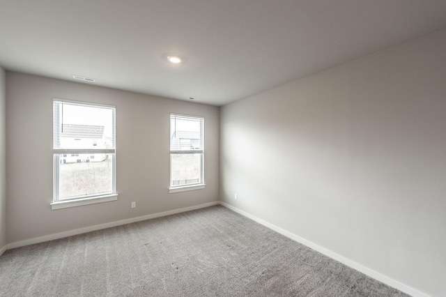 spare room featuring baseboards and carpet floors