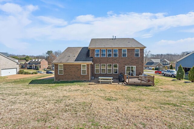 rear view of property featuring a residential view, brick siding, a lawn, and a wooden deck