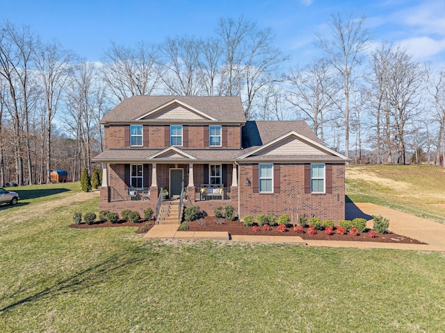 view of front of property with a front lawn, a porch, and brick siding