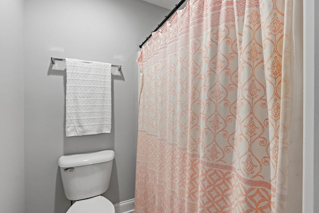 bathroom with a shower with curtain and toilet