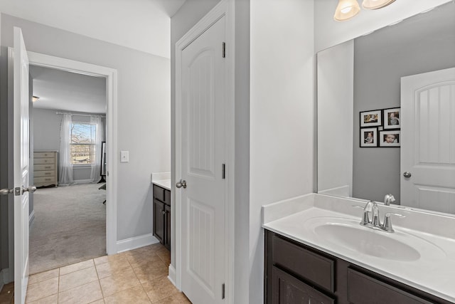 bathroom with vanity, baseboards, and tile patterned floors