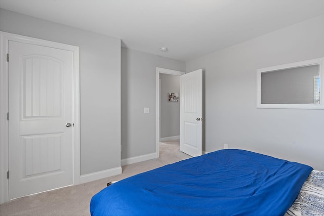 bedroom featuring light carpet and baseboards