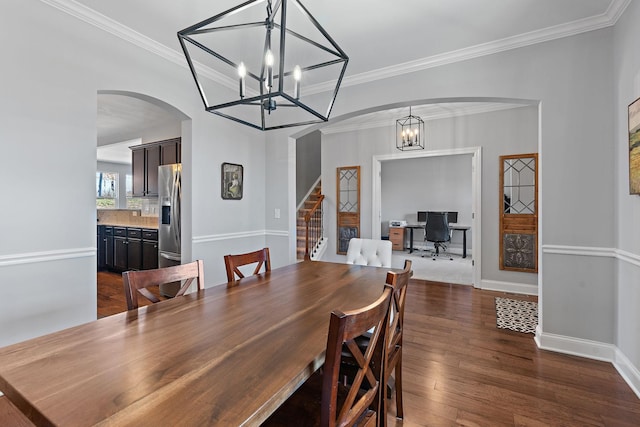 dining space with crown molding, a notable chandelier, dark wood finished floors, and baseboards