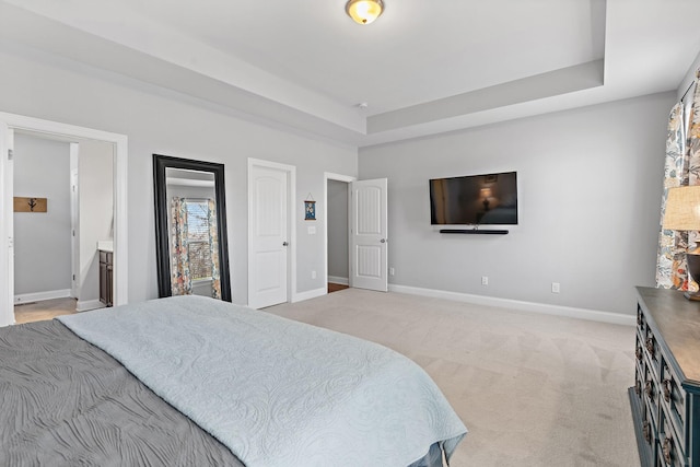 bedroom with light carpet, baseboards, and a tray ceiling