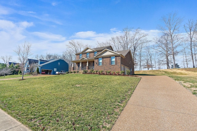 traditional home with a garage, brick siding, driveway, and a front yard