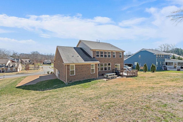 back of house with a residential view, a lawn, and brick siding