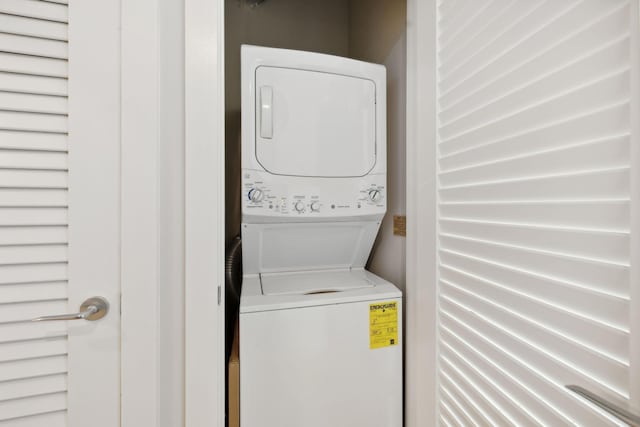 clothes washing area with laundry area and stacked washing maching and dryer