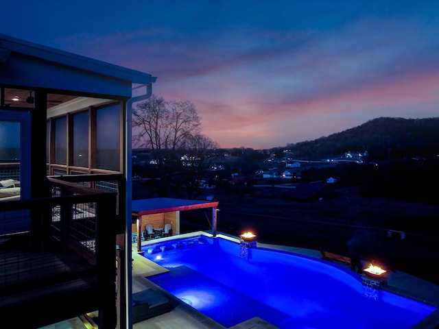 pool at dusk featuring an outdoor pool