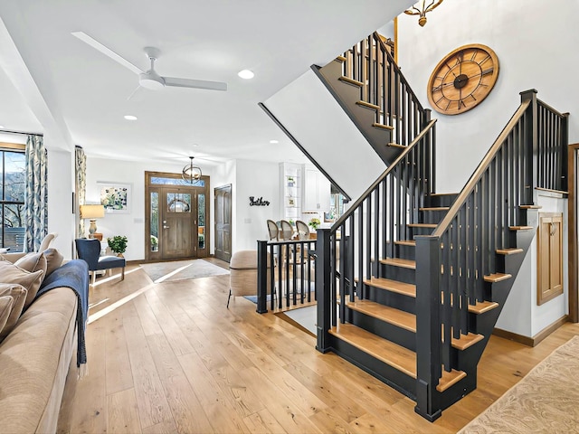 entryway with light wood finished floors, stairs, baseboards, and recessed lighting