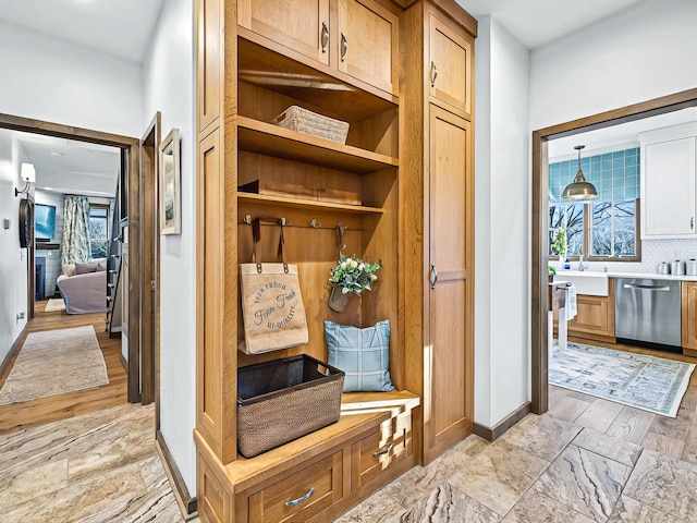 mudroom with a sink and baseboards