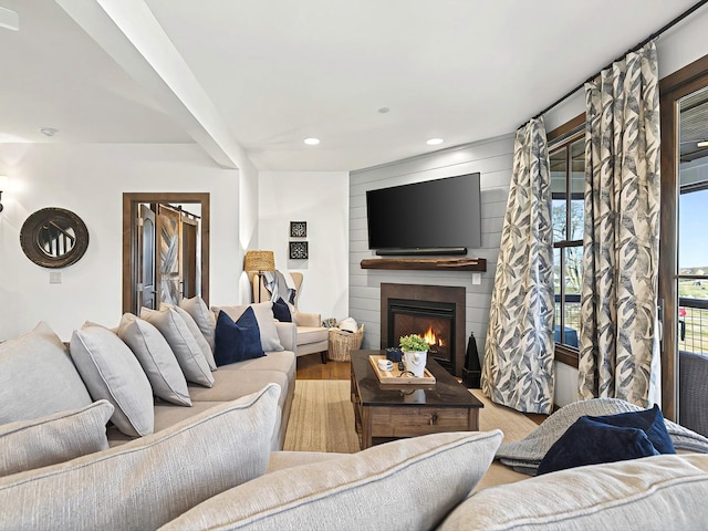 living room with recessed lighting, a large fireplace, and wood finished floors