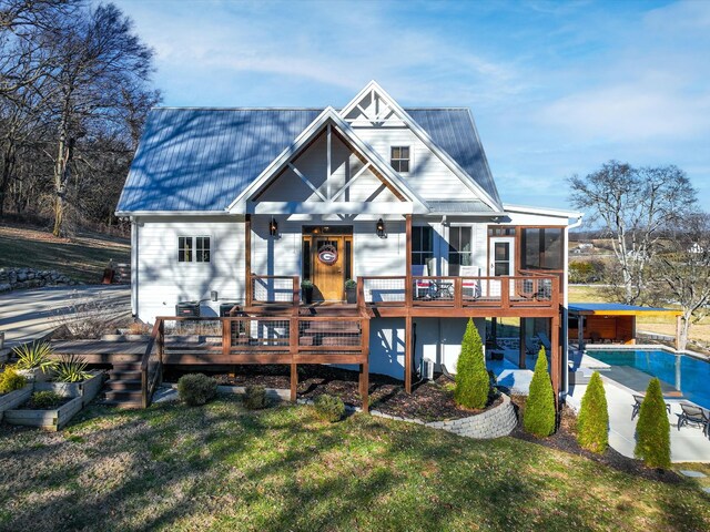 rear view of house featuring a yard, metal roof, and a wooden deck