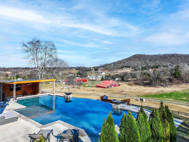 pool featuring a patio and a mountain view