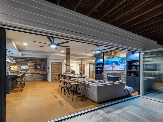 living room featuring ceiling fan, a fireplace, and decorative columns