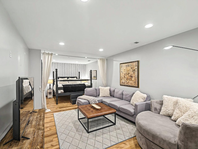 living area featuring light wood-type flooring, visible vents, and recessed lighting