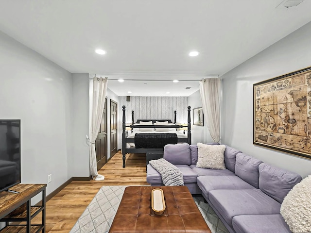 living room featuring recessed lighting, baseboards, visible vents, and light wood finished floors