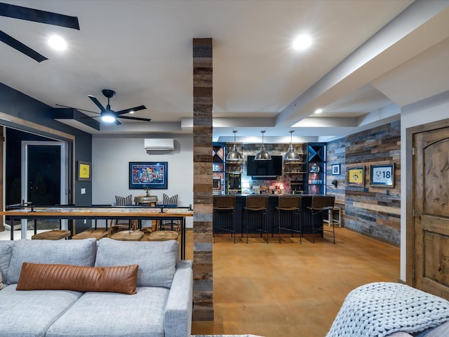 living area with ceiling fan, recessed lighting, an AC wall unit, wet bar, and finished concrete floors