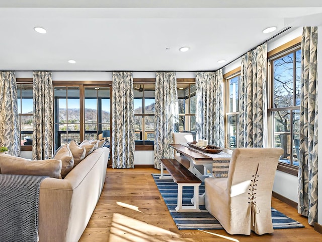 living room featuring a healthy amount of sunlight, baseboards, wood finished floors, and recessed lighting