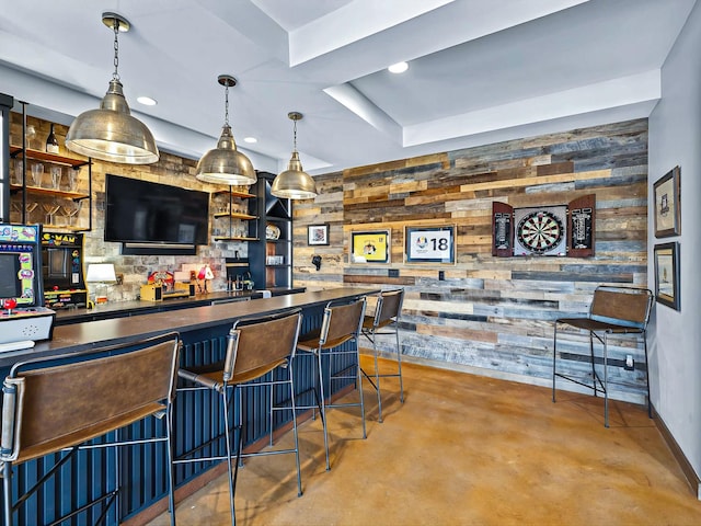 bar with finished concrete flooring, wet bar, decorative light fixtures, and wooden walls