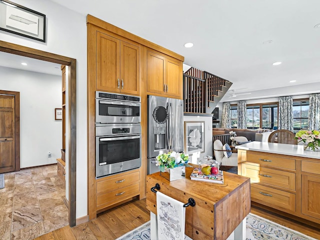 kitchen with appliances with stainless steel finishes, recessed lighting, open floor plan, and baseboards