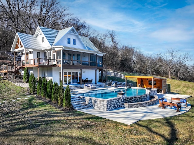 back of house with metal roof, a sunroom, stairs, a yard, and a patio area