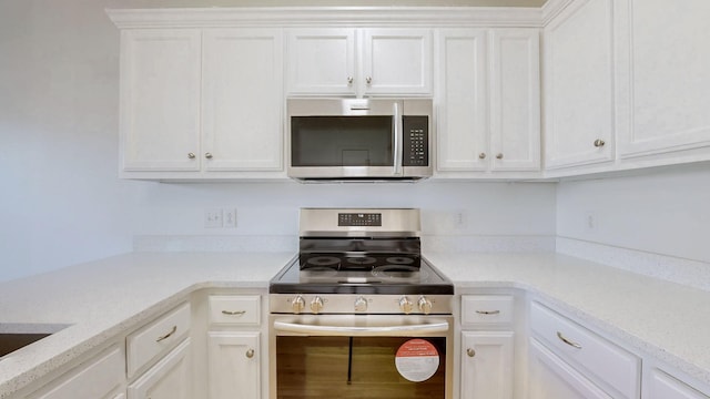 kitchen with white cabinets and appliances with stainless steel finishes