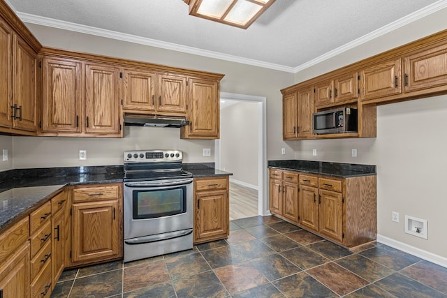 kitchen with baseboards, brown cabinetry, dark stone countertops, stainless steel appliances, and under cabinet range hood