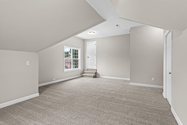 additional living space featuring lofted ceiling, baseboards, and carpet flooring