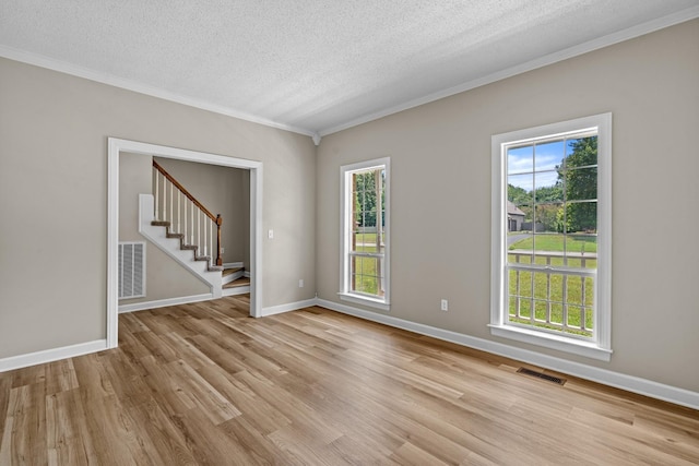 empty room with visible vents, plenty of natural light, and light wood finished floors