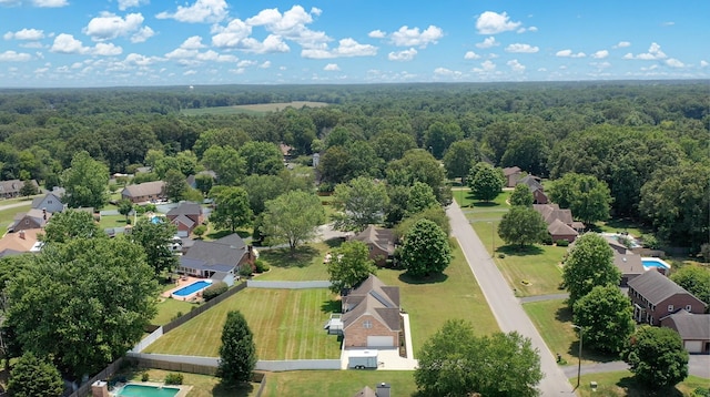 drone / aerial view featuring a residential view and a view of trees