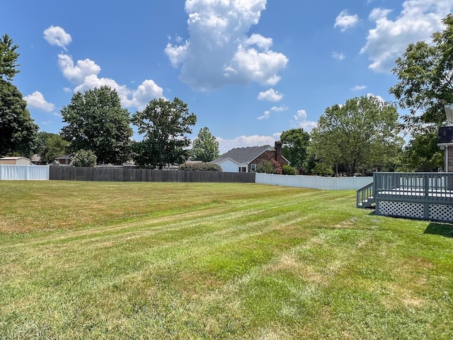 view of yard featuring fence and a deck