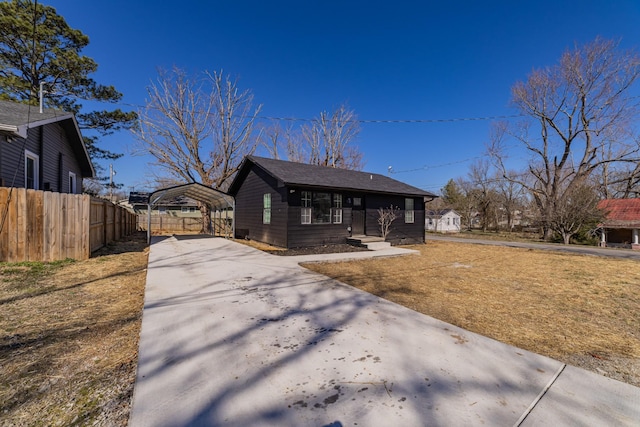 view of front of home featuring a carport, a front yard, concrete driveway, and fence