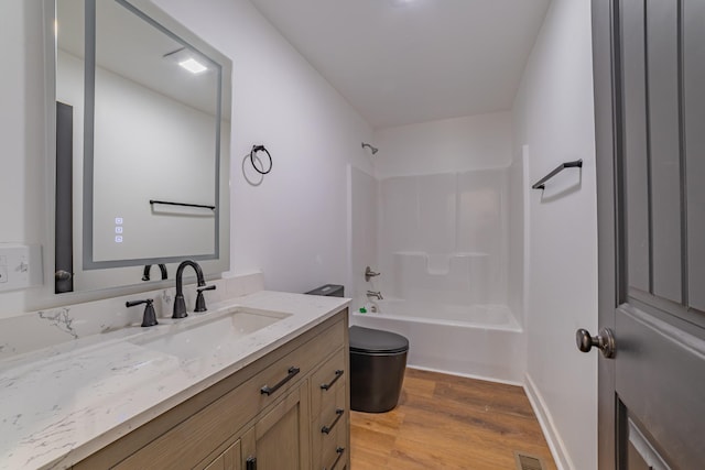 bathroom featuring visible vents, toilet, wood finished floors, bathtub / shower combination, and vanity