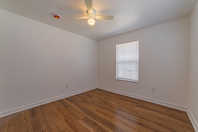 unfurnished room with wood finished floors, a ceiling fan, and baseboards