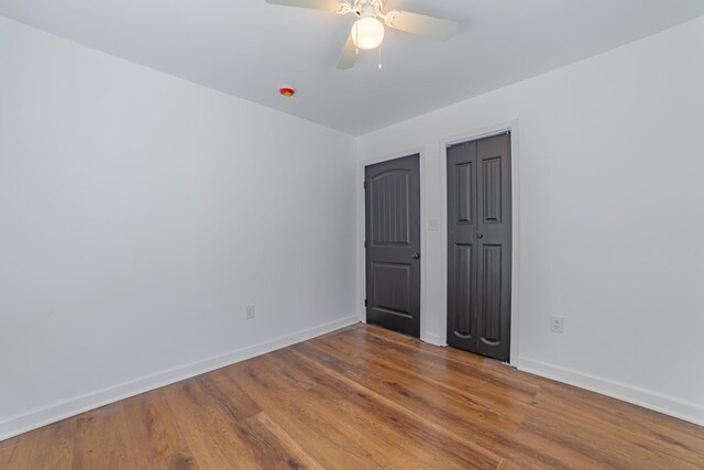 unfurnished room with a ceiling fan, baseboards, and wood finished floors