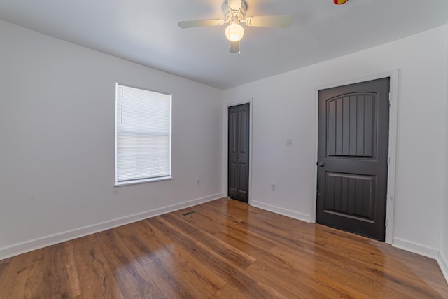 unfurnished bedroom with a ceiling fan, baseboards, and wood finished floors