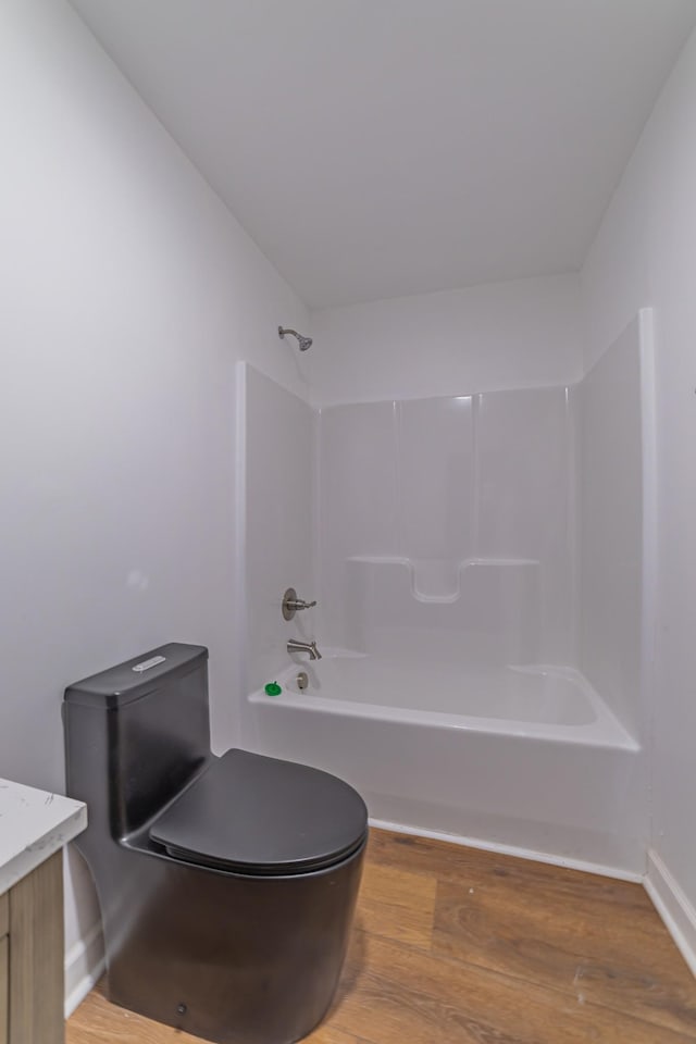 bathroom featuring toilet, bathtub / shower combination, wood finished floors, and vanity