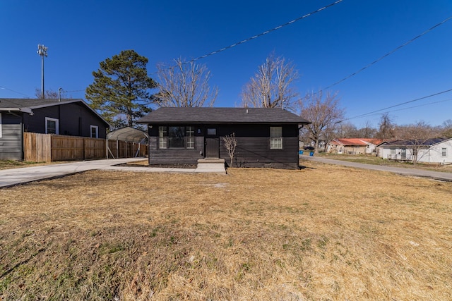 view of front of house with a front yard, fence, and driveway