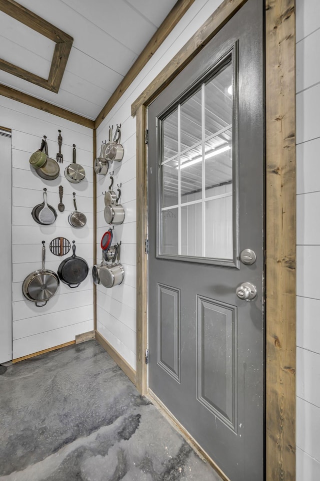 interior space with concrete floors and wood walls