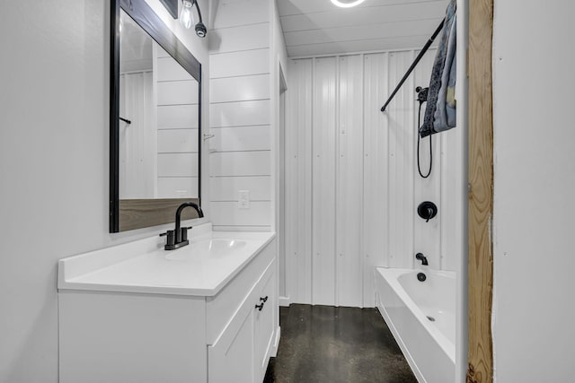 bathroom with wooden walls, concrete floors, shower / washtub combination, and vanity